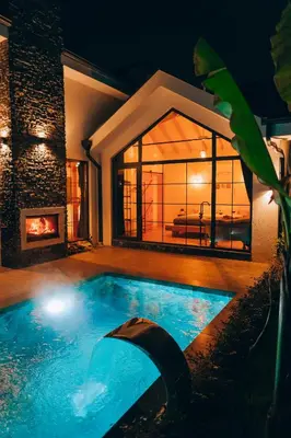 a swimming pool in front of a house with a fireplace at Villa Ulusoy Sapanca in Sapanca