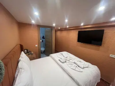 a hotel room with a bed and a flat screen tv at Cemre Homes in Istanbul