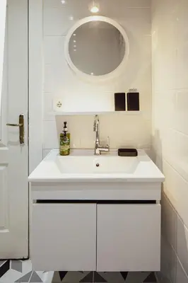 a white bathroom with a sink and a mirror at Raya Suites in Istanbul