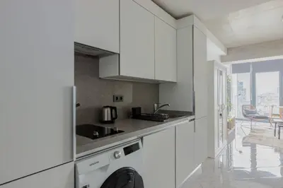 a kitchen with white cabinets and a counter top at Cozy Bright Studio! ParkingGymPool Access! #374 in Istanbul