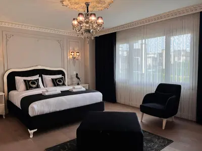 a bedroom with a bed and a chair and a chandelier at Nil Konaklama Sapanca in Sapanca