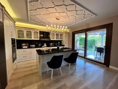 a kitchen with a large island with chairs and a chandelier at Nil Konaklama Sapanca in Sapanca