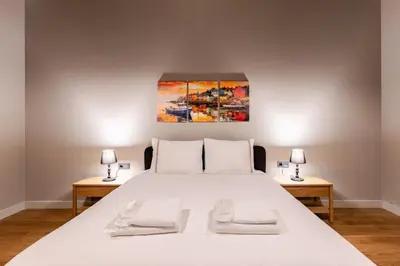 a bedroom with a large white bed with two tables at Beautiful Deluxe 1BD Condo PoolGymParking! #373 in Istanbul