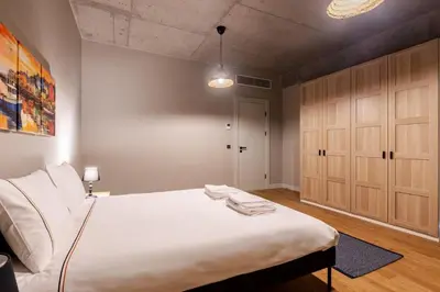 a bedroom with a large white bed and wooden cabinets at Beautiful Deluxe 1BD Condo PoolGymParking! #373 in Istanbul