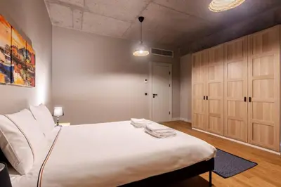 a bedroom with a large white bed and wooden cabinets at Beautiful Deluxe 1BD Condo PoolGymParking! #373 in Istanbul