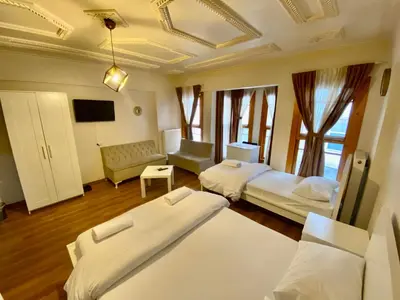 a hotel room with two beds and a tv at Konak Akaretler Suit in Istanbul