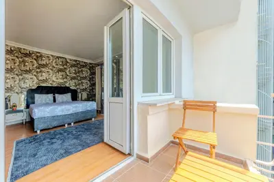 a bedroom with a bed and a wooden chair at Palas Apartments in Istanbul