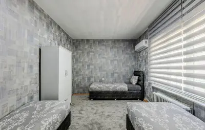 a bedroom with two beds and a chair in it at Palas Apartments in Istanbul