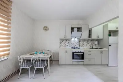 a kitchen with white cabinets and a table and chairs at Palas Apartments in Istanbul