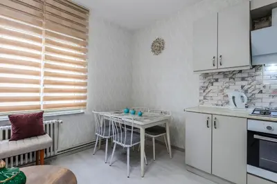 a kitchen with white cabinets and a table with chairs at Palas Apartments in Istanbul