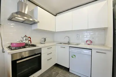 a kitchen with white cabinets and a stove top oven at Kardes Apartment in Istanbul