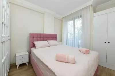 a bedroom with a pink bed with a pink headboard at Kardes Apartment in Istanbul
