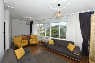 a living room with a couch and yellow chairs at Nasiroglu Apartment in Istanbul