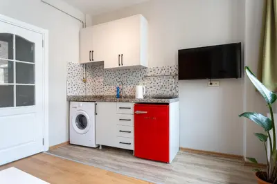 a kitchen with a washing machine and a red refrigerator at Lovely and Snug Flat, Just Steps from Istiklal Street in Istanbul