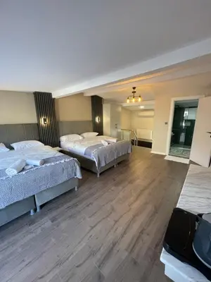 two beds in a large room with wooden floors at Golden Arrow delüx Dublex in Istanbul