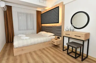 a bedroom with a bed and a vanity and a mirror at Bomonti Apartments in Istanbul