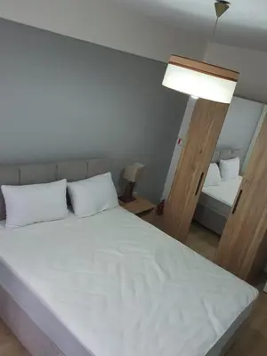 a bedroom with a large white bed with a lamp at Fully Renovated apartment in Istanbul