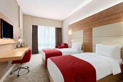 a hotel room with two beds and a desk at Ramada Encore Istanbul Kartal in Istanbul