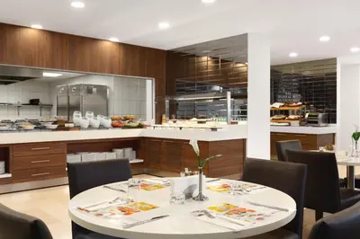 a restaurant with a table and chairs and a kitchen at Ramada Encore Istanbul Kartal in Istanbul