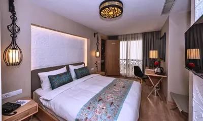 a bedroom with a large bed and a desk at Aybar Hotel & Spa in Istanbul