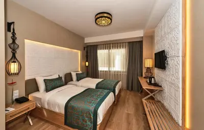 a hotel room with two beds and a television at Aybar Hotel & Spa in Istanbul