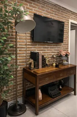 a room with a desk with a television on a brick wall at The Print House Hotel in Istanbul