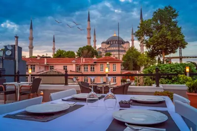 a table on a balcony with a view of the blue mosque at Sarnic Hotel & Sarnic Premier Hotel(Ottoman Mansion) in Istanbul
