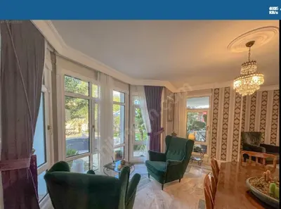 a living room with green chairs and a chandelier at Kilyos Serendipity in Sarıyer