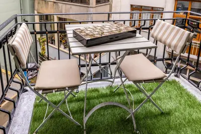 a table and chairs on a balcony with grass at Respiro Rooms in Istanbul