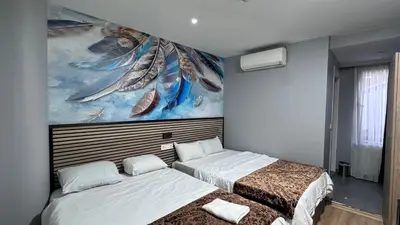 two beds in a room with a painting on the wall at Rozza Hotel in Istanbul