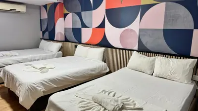 two beds in a room with a mural on the wall at Rozza Hotel in Istanbul