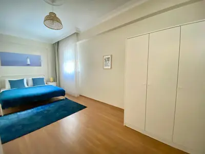 a bedroom with a blue bed and a large cabinet at Spacious & City Center 3 Bedroom Flat - No2 in Istanbul