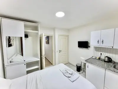 a white kitchen with a bed and a sink at Taksim Seven Residence in Istanbul