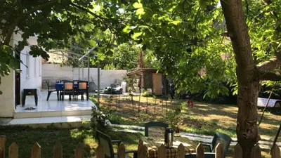 a backyard with a table and chairs and a tree at Rahat bahçeli polonezköyde butik evimiz in Beykoz