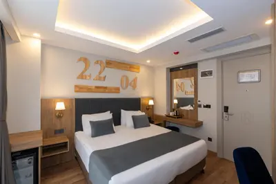 a bedroom with a large bed and a desk and a room at Harmony Hotel Istanbul & SPA in Istanbul