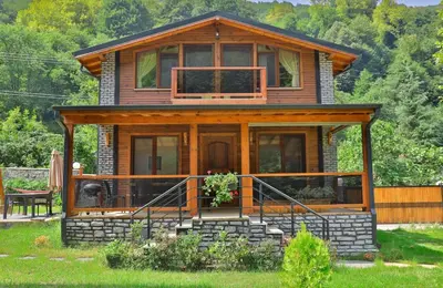a log home with a large window and a porch at Lal Hayal Konakları in Sapanca