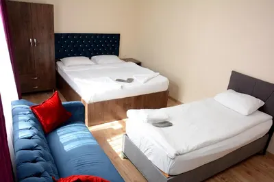 a small room with two beds and a couch at palmiye suıt otel in Istanbul