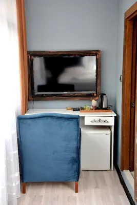 a blue chair in front of a desk with a television at palmiye suıt otel in Istanbul
