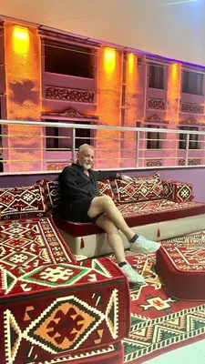 a man sitting on a couch in a room with carpet at Istanbul Family Apartment in Istanbul