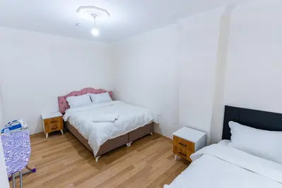 a bedroom with two beds and two tables and a bed sidx sidx sidx at Lina Apart in Arnavutköy