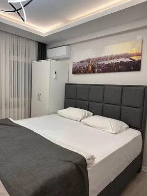 a bedroom with a large bed with a painting on the wall at ZARA'S HOME in Istanbul in Istanbul