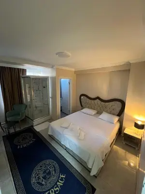 a bedroom with a large white bed and a blue rug at The walens hotel in Istanbul