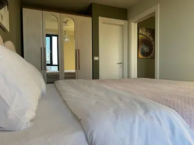 a white bed in a bedroom with a mirror at Take Me Home in Istanbul