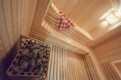 a corner of a sauna with a basket of rocks at Lamec Hotel Business in Gebze