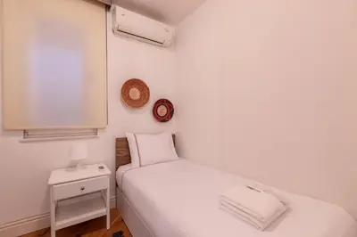 a small white bedroom with a bed and a nightstand at Luxury Modern 3Bed25Bath Central Bright Pad #375 in Istanbul