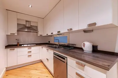 a kitchen with white cabinets and a wooden floor at Luxury Modern 3Bed25Bath Central Bright Pad #375 in Istanbul
