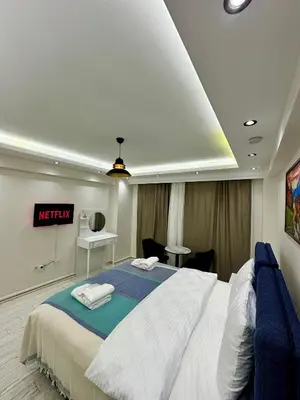 a bedroom with a large bed and a desk at Öz Suit in Istanbul