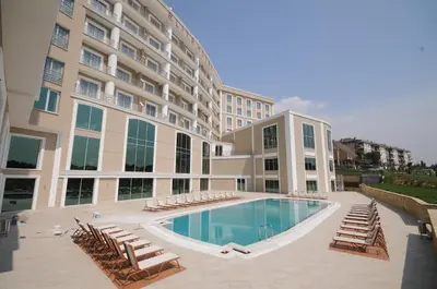 a large building with a swimming pool and lounge chairs at Elite Hotels Darica Spa & Convention Center in Gebze