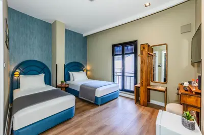 a hotel room with two beds and a mirror at Nenessa Airport Hotel in Arnavutköy