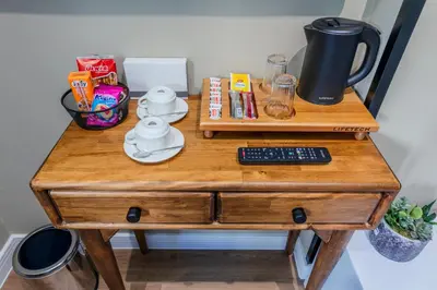 a wooden table with a remote control on top of it at Nenessa Airport Hotel in Arnavutköy